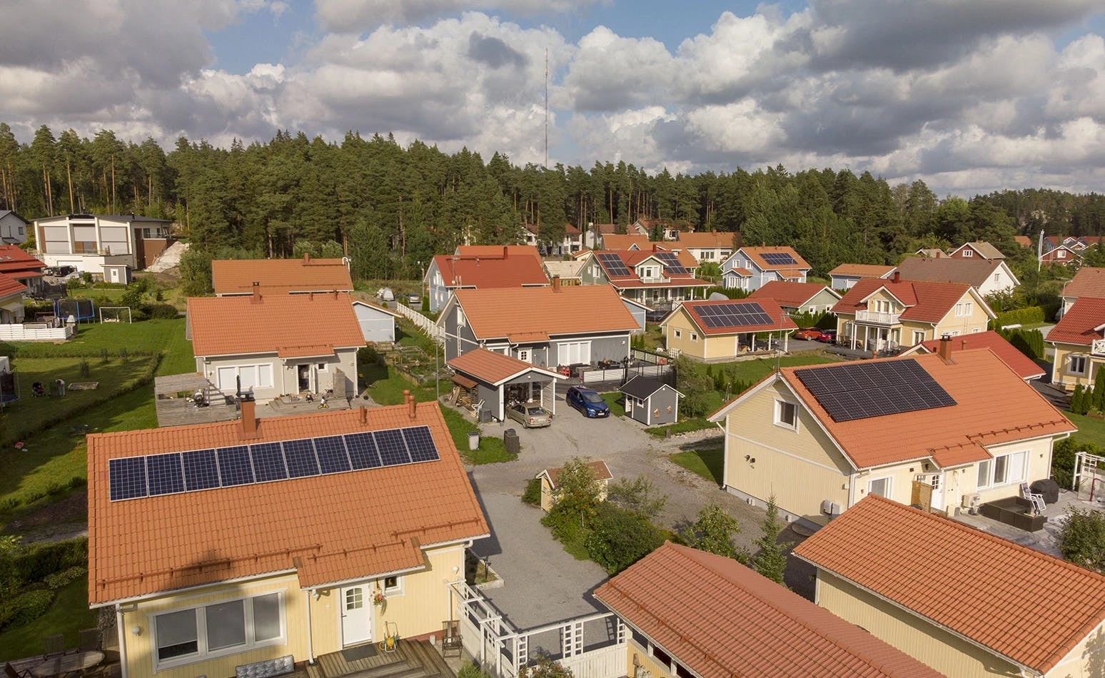 Asuinalue jossa monta aurinkopaneelijärjestelmää katoilla